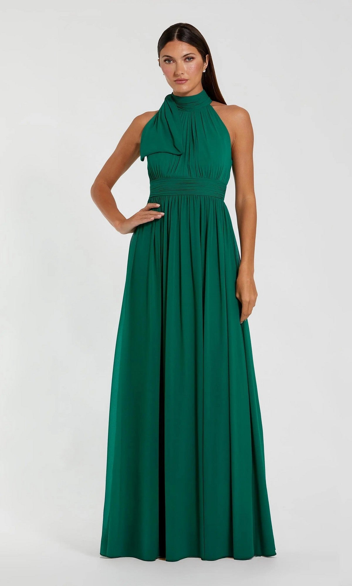A woman models the Mac Duggal 55035 high-neck, sleeveless formal dress with a gathered waist in floor-length green, set against a plain light background.